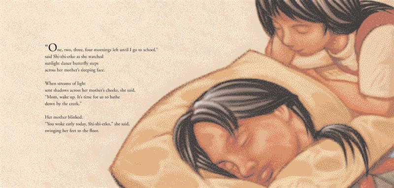  Two people with medium skin tone are lying down. One is under the covers with closed eyes. The other watches them. Text: “One, two, three, four mornings left until I go to school,” said Shi-shi-etko as she watched sunlight dance butterfly steps across her mother’s sleeping face. When streams of light sent shadows across her mother’s cheeks, she said “Mom, wake up. It’s time for us to bathe down by the creek.” Her mother blinked. “You woke early today, Shi-shi-etko,” she said, swinging her feet to the floor. 