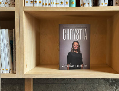 A photo of the book Chrystia by Catherine Tsalikis standing in a wooden bookshelf. 