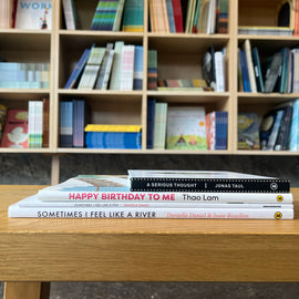  Photo of books featured in the Developing Emotional Awareness bundle. The books are stacked on a wooden stool, with bookshelves in the background. The spines face out. 
