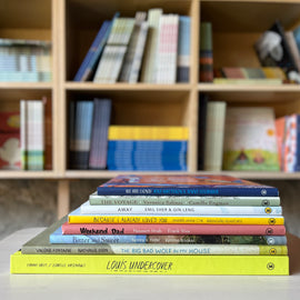  Photo of the books in the Navigating Family Issues Bundle stacked on a wooden stool, with bookshelves in the background. The spines face out.  