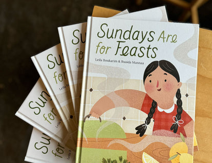 A photo of copies of Sundays Are for Feasts fanned out on a wooden table. 