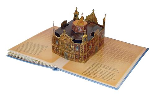  This image shows a photograph of a pop-up book. The pop-up is of a large ornate building with a cross at the top each tower. 