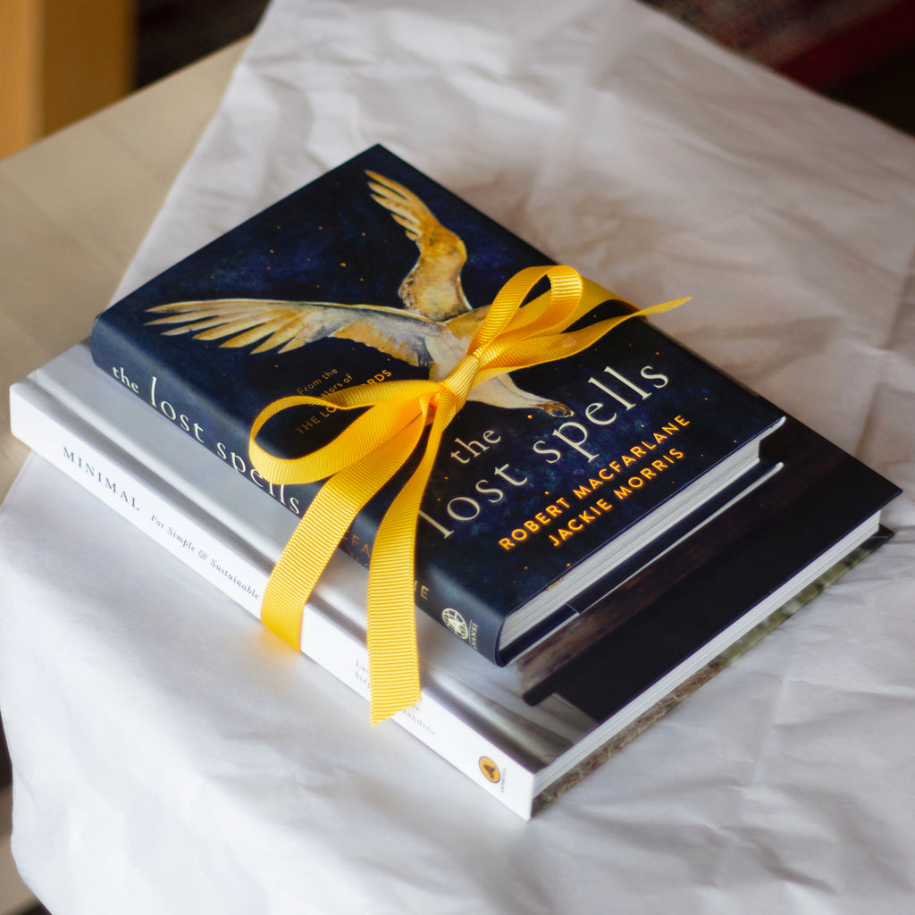  A photo of copies of Minimal: For Simple and Sustainable Living and The Lost Spells wrapped together with a yellow ribbon. 